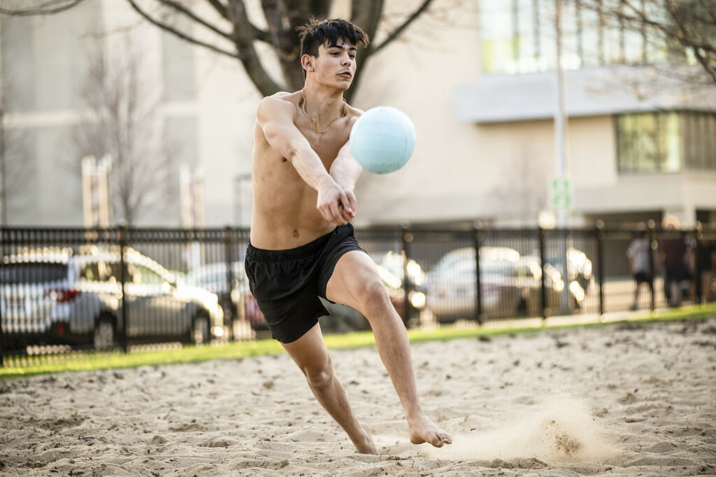 A student passes the ball while playing volleyball on the Witte sand court.
