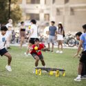 Students stand around a small trampoline that's the center of the spikeball game.