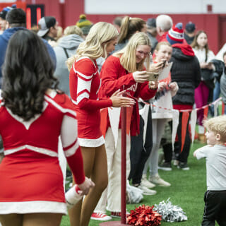 A young child high-fives members of the spirit squad.