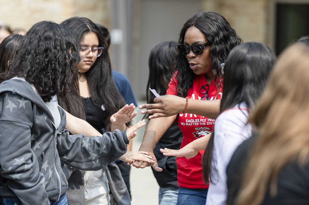 A woman helps out some students.