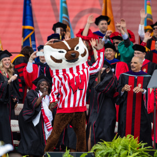 People on stage dance with mascot Bucky Badger.