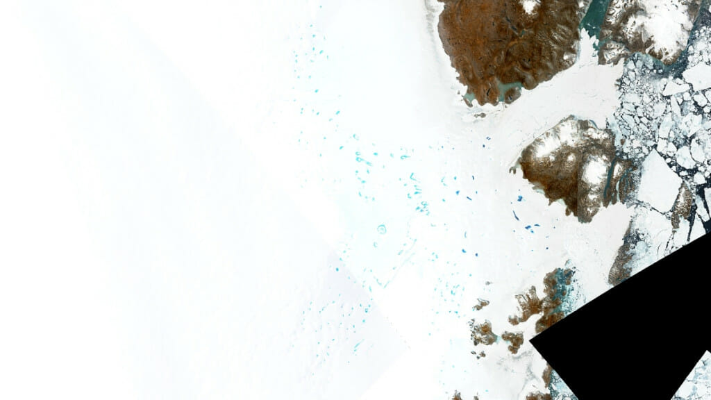 In an aerial photograph taken from a Sentinel-2 satellite, bright blue ponds of meltwater dot the ice of northeast Greenland.