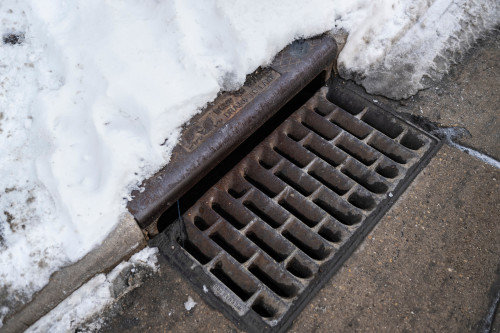 A City of Madison stormwater grate on surrounded by snow