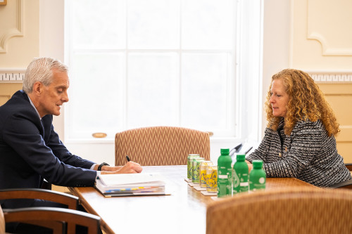 At left, U.S. Secretary of Veterans Affairs Denis McDonough speaks with Chancellor Jennifer Mnookin in Bascom Hall. They are seated across from each other at a conference table.