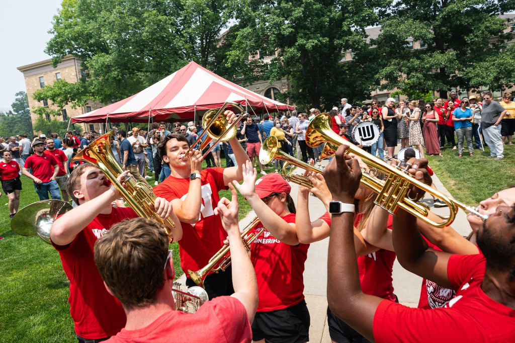 Six members of the UW Marching Band's brass section point their instruments to the sky as they play a rousing number on Bascom Hill.