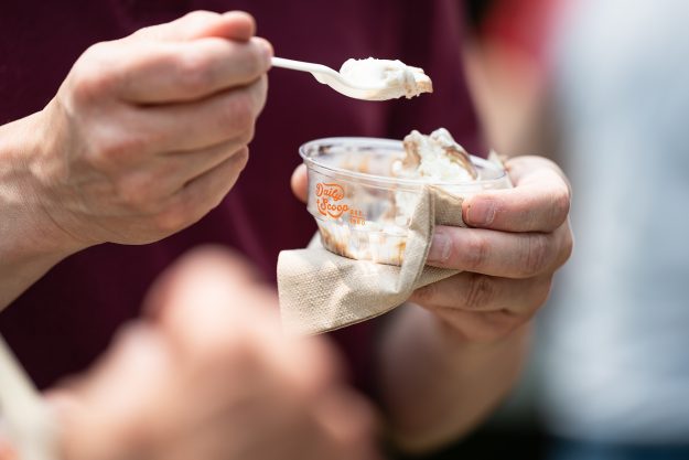 近距离射杀一个人的手捧一杯冰淇淋,用汤匙挖一口。