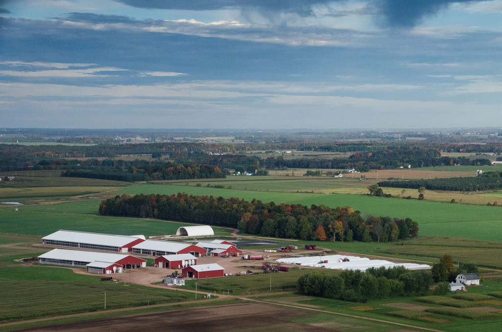 An aerial view shows buildings among farm fields.
