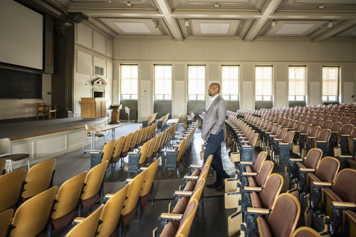Charles Isbell walks down the center isle of an empty lecture hall.