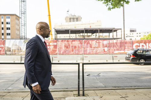 Charles Isbell walks down University Avenue. The construction site for the new School of Computer, Data & Information Sciences building is behind him.
