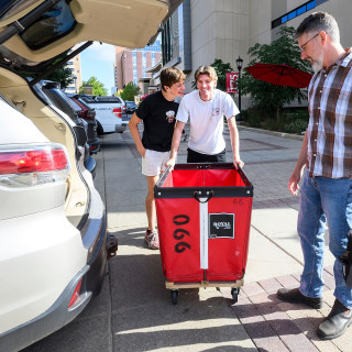 The Elmore family prepares to unload Elmore’s belongings from the car for his move-in to Ogg Residence Hall.