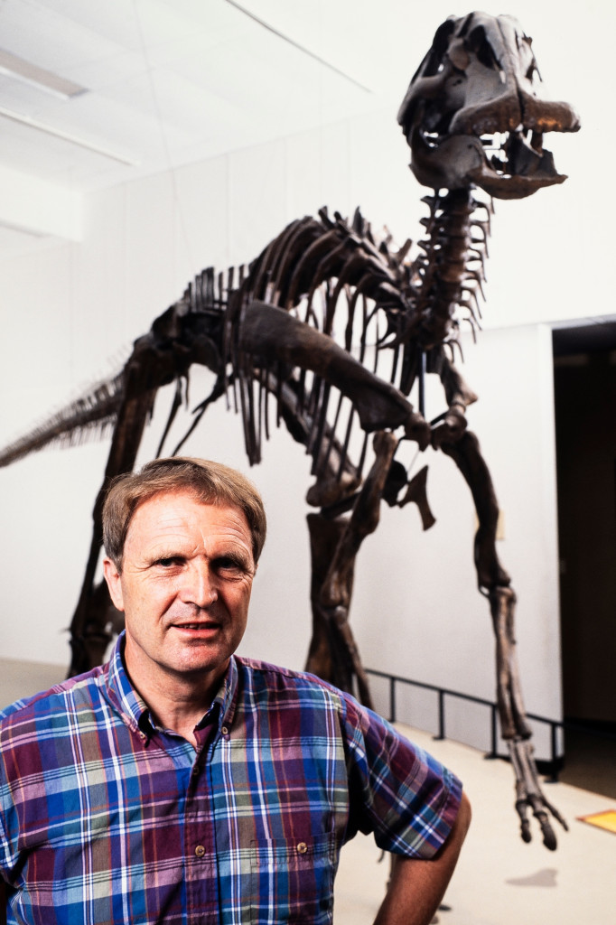 Klaus Westphal stands in front of a large dinosaur skeleton on display in a white museum gallery.