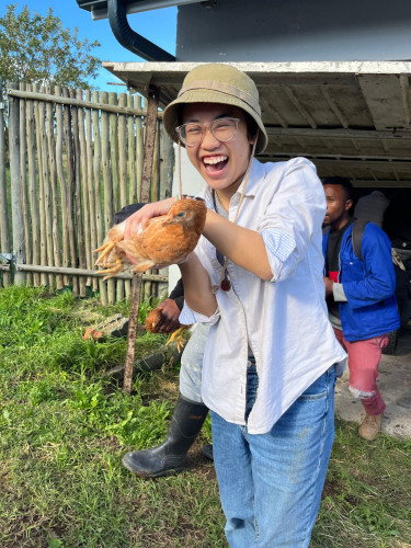 A woman is shown holding a chicken.