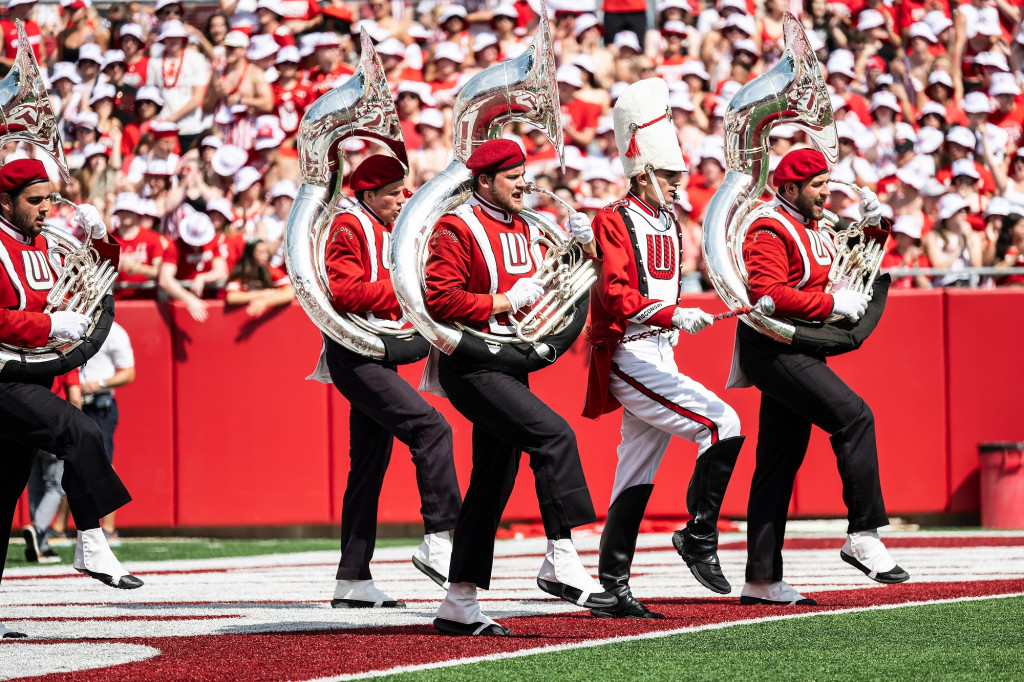 Four people playing tubas march through the end zone.