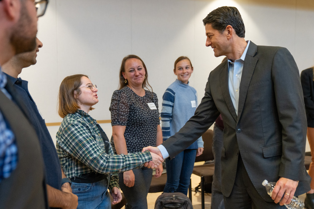 A man shakes a woman's hand.