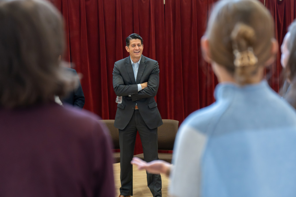 A man sits in a circle with others and talks.