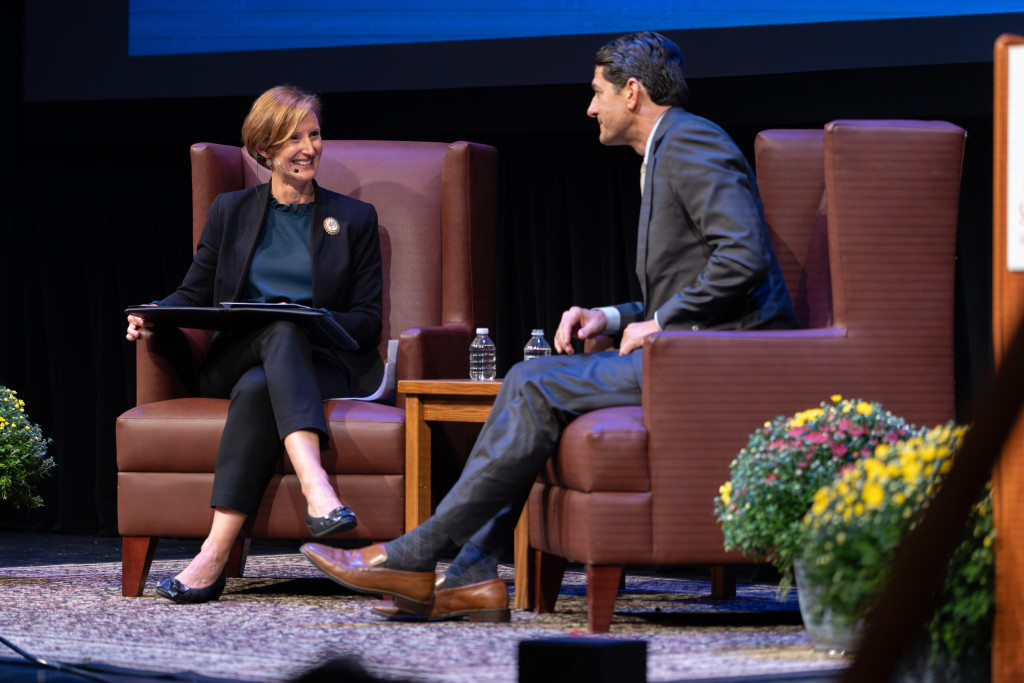 A man sits in a chair across from a woman.