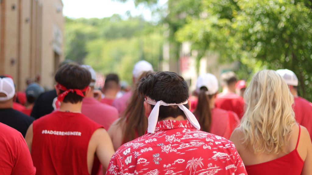 People dressed in red walk to a stadium on Game Day.