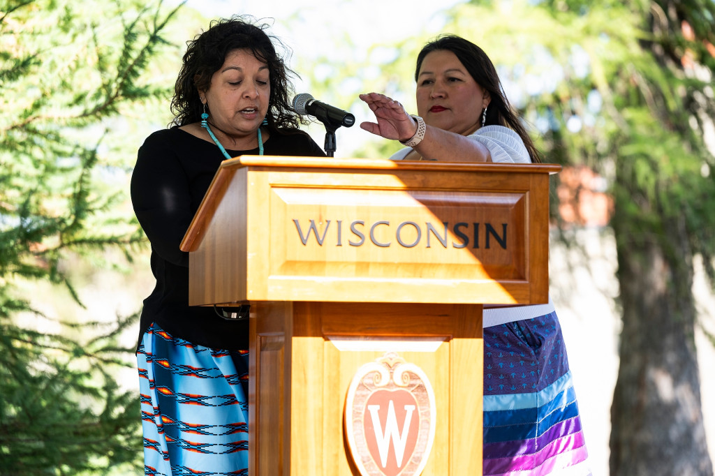 Two women are shown at a podium.