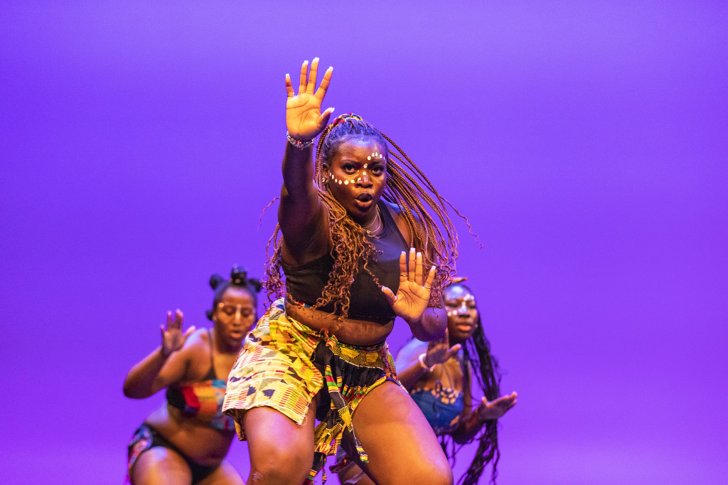 A woman leads a dance on stage.