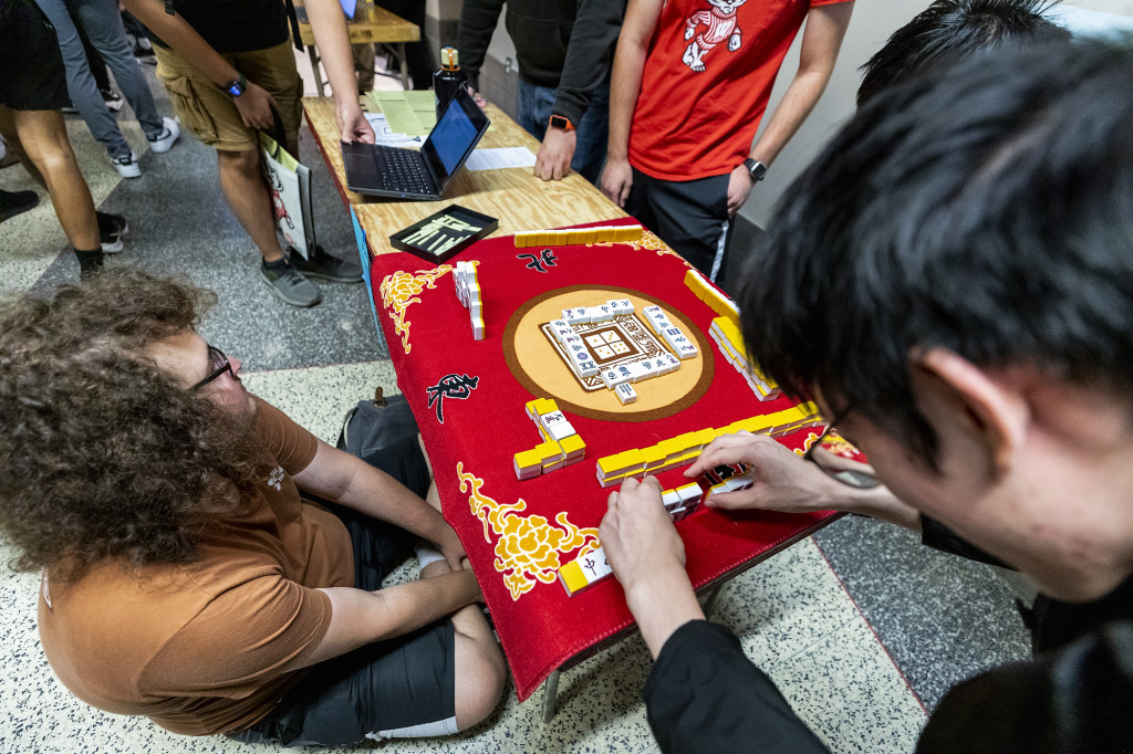 People sit at a board playing a game.