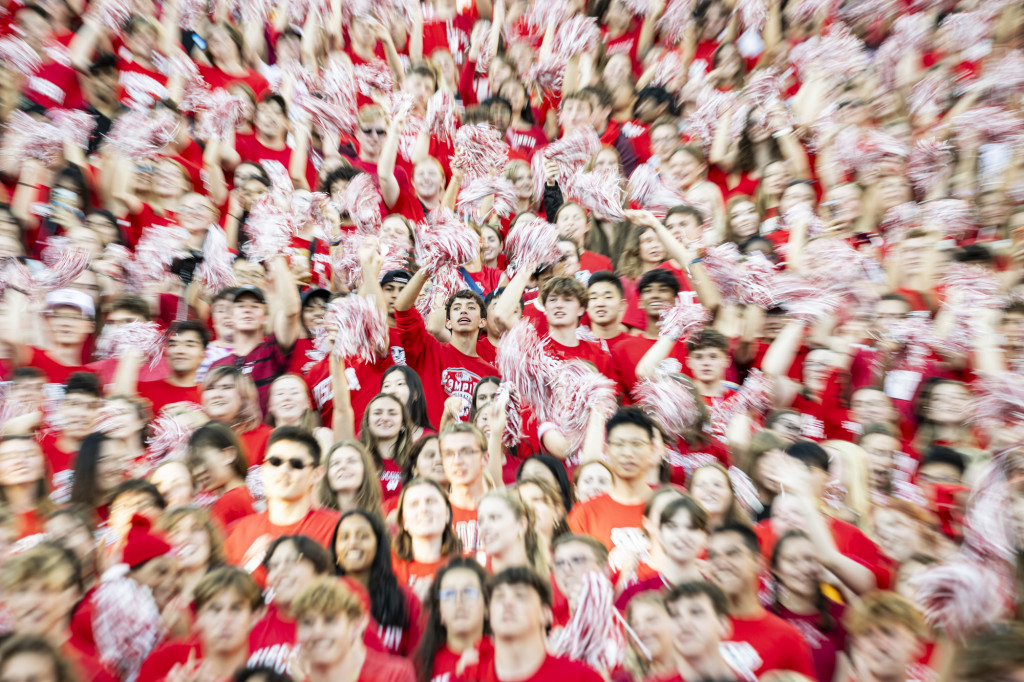 A scene of students wearing red and smiling fills the frame.