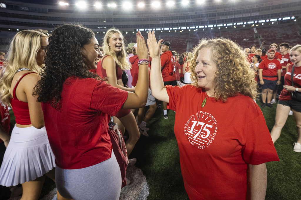 Down on the field, Chancellor Mnookin gives a student a high-five.