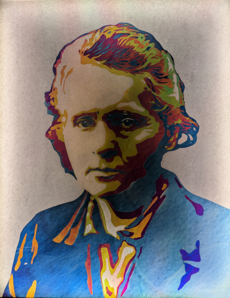 An image of Mary Curie rendered in a colorful Pop Art style. Her hair is filled in with shades of blue, yellow, magenta, green and orange. Similar shades fill in her face and clothing.