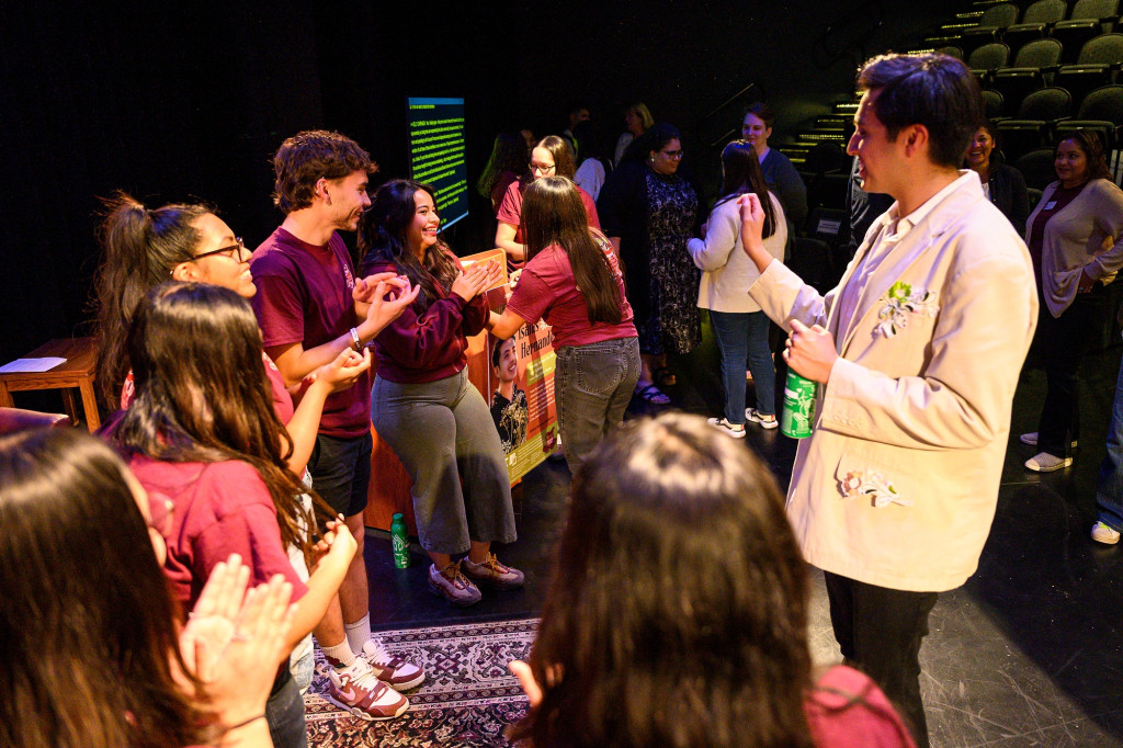 A presenter stands in front of a group of student after a keynote presentation.