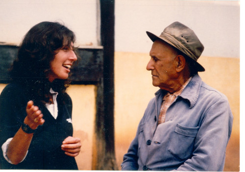 A woman smiles as she speaks to the man next to her.