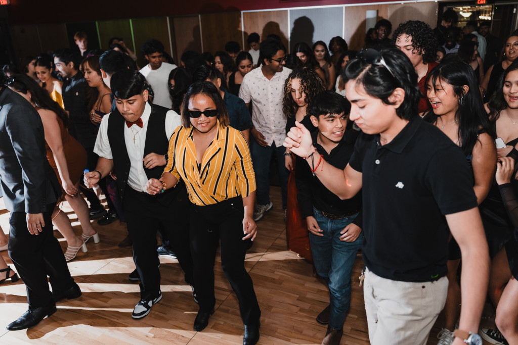 A large group of people dance on the dance floor.