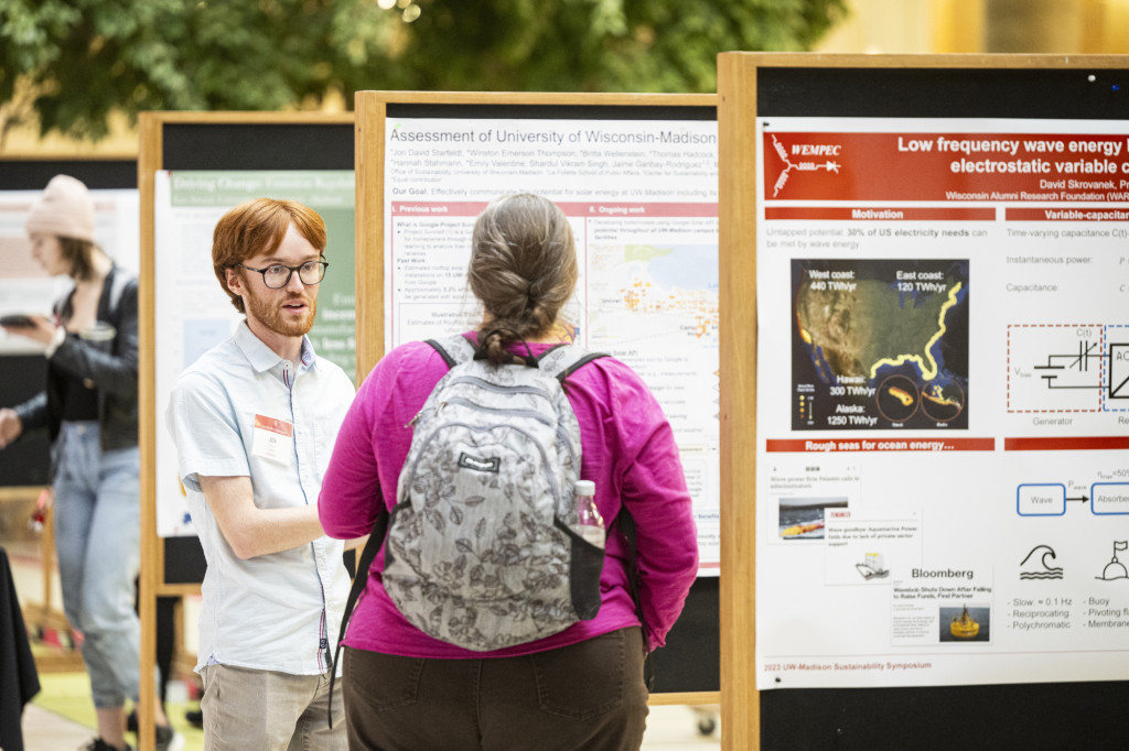 A man talks with others about his poster.