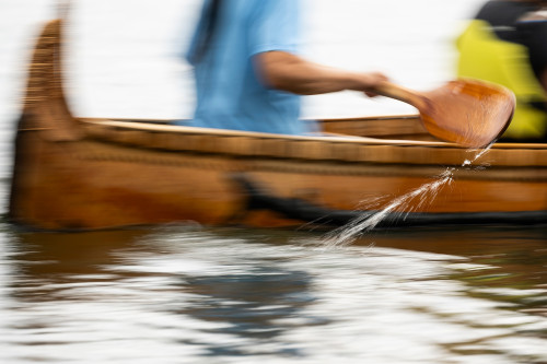 A photo with blurred motion shows the canoe moving swiftly through the water.