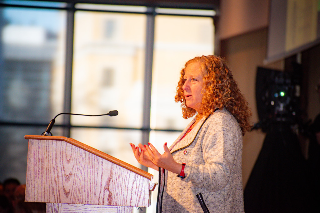 A woman speaks at a podium.