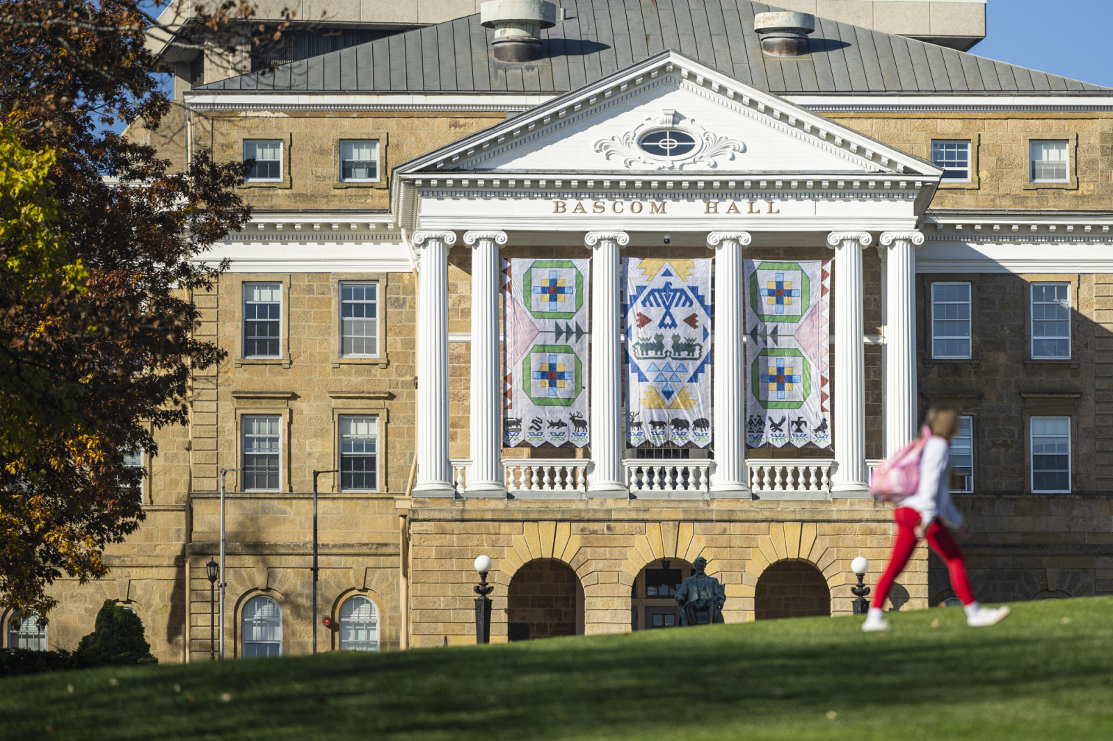 A view over the crest of Bascom Hill looking toward the Seed by Seed banners hanging on Bascom Hall.