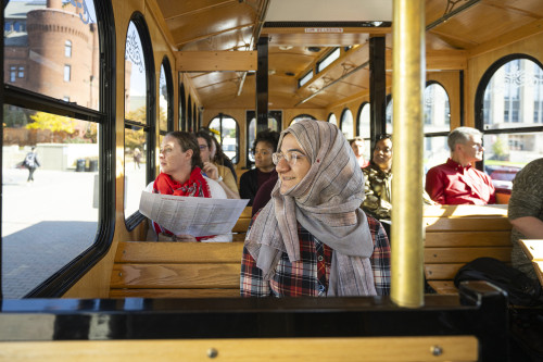 A view of passengers on the bus shows new employees looking out the windows as they pass buildings on UW's campus.