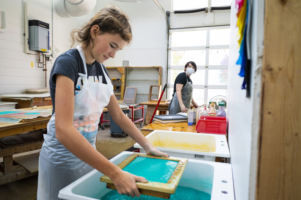 Kate Flake, an MFA graduate candidate, demos a paper-making process with Maggie Hinterthuer (left).