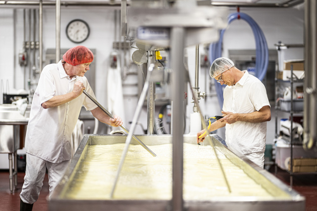 Jaeggi, left, and Babcock Dairy Plant supervisor Dave Niemiec mix the milk and other ingredients. They will  then allow time for the milk to coagulate into curd.