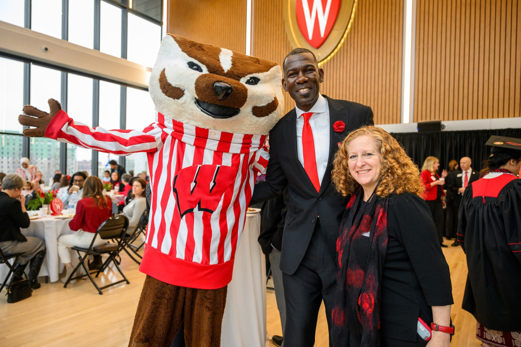 Two people and a mascot pose for the camera.
