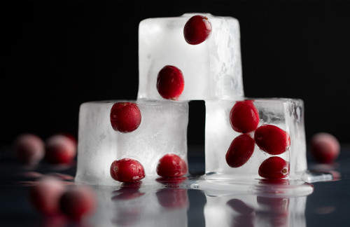 Cranberries frozen into three stacked ice cubes.