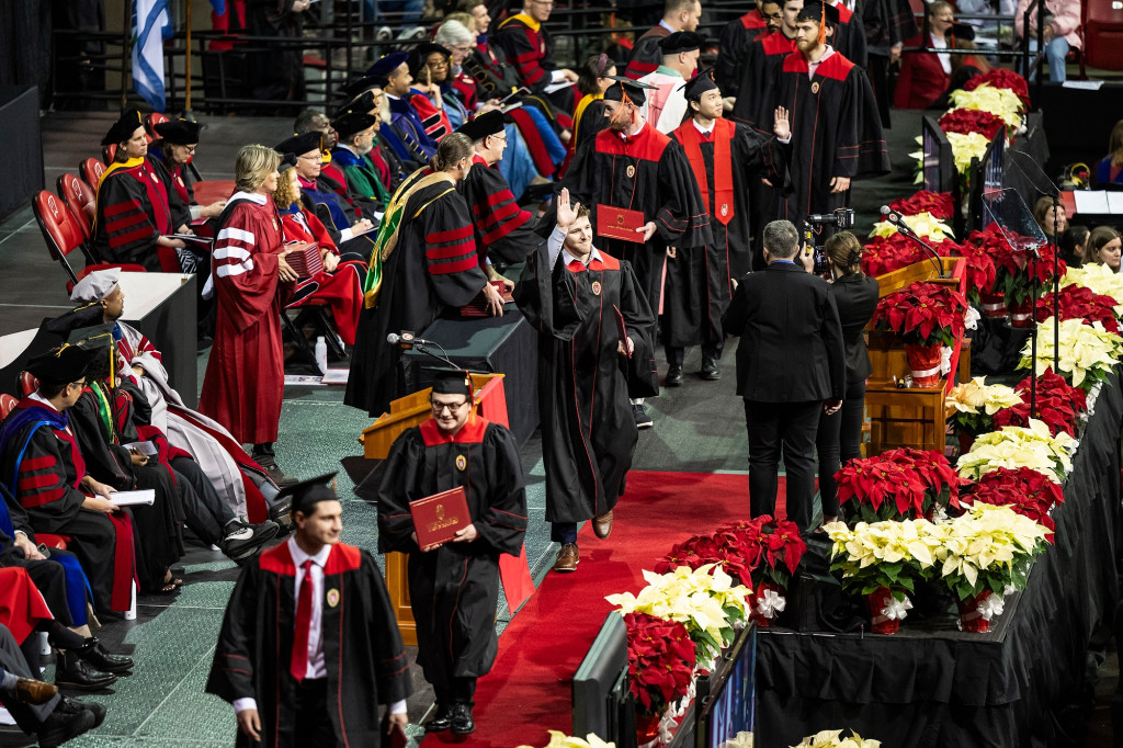 Graduates walk across the stage.