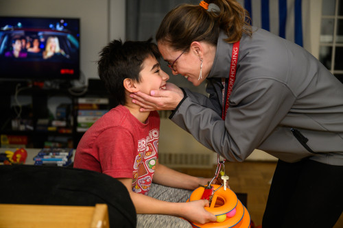 A woman and a young boy look each other in the eye, pulling together closely.