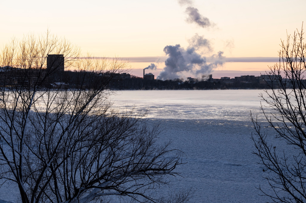 With the sun setting, steam rises off a lake.