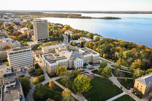 An aerial photo of the UW–Madison campus shows Bascom Hall in the foreground and Lake Mendota in the background.
