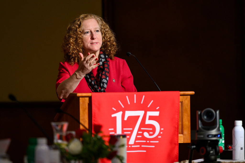 Photo of Jennifer Mnookin speaking from a podium. Draped over the top of the podium is a red banner with then number 175 printed in white.