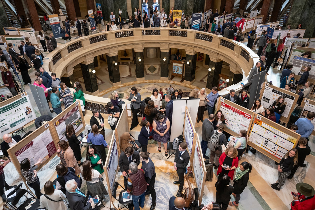 A view from above of people gathered around the capital rotunda showing their poster boards displaying research projects.