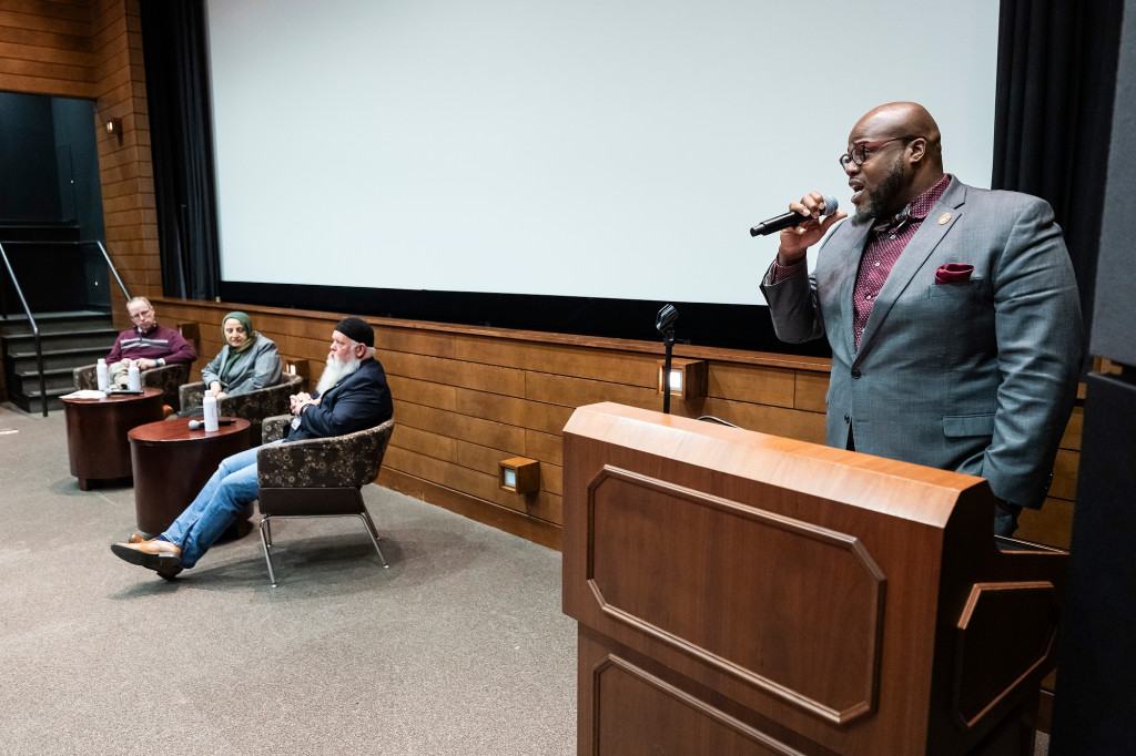 LaVar Charleston stands at a podium and speaks into a microphone while introducing the panel after the film screening.