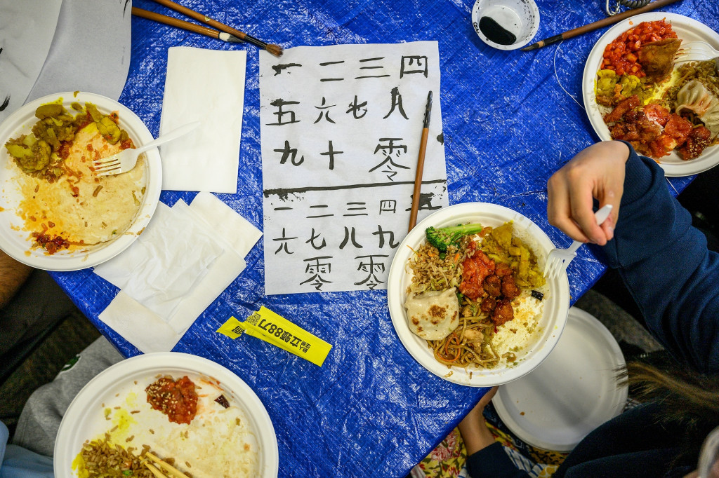 Plates of food and samples of calligraphy adorn a table.