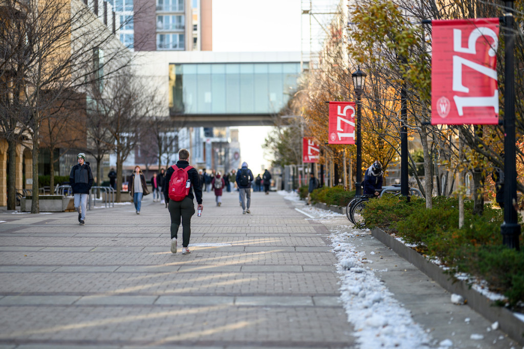 People walk on an open campus mall.