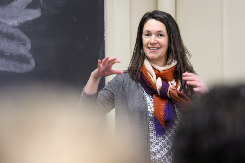 Photo of Barbara Rodríguez-Guridi standing at the front of a classroom and smiling as she speaks and gestures with her hands.