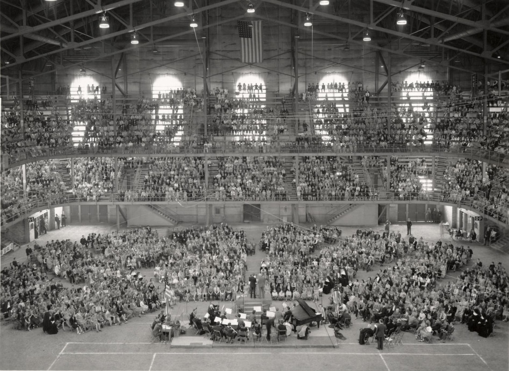 A black-and-white photo of spectators filling bleachers at an old-fashioned field house.